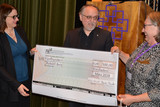 Ursula Kuhn aus dem Dekanatssynodalvorsand (links) und Präses Gabriele Schmidt (rechts) überreichen den symbolischen Scheck von 500 Euro an Robert Belz.