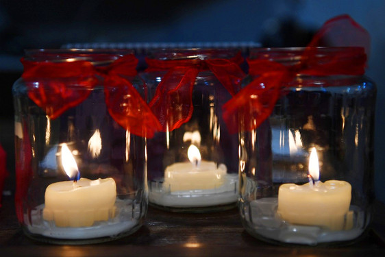 Kerzen im Glas stehen an Allerheiligen auf den Gräbern