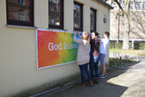 Am Kinder- und Jugendhaus der Pfarrei St. Birgid in Bierstadt bringen die Mitglieder des AK Jugend das Banner an.