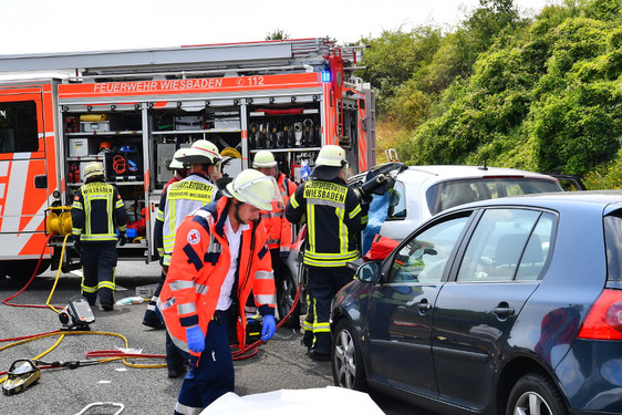 Heftiger Auffahrunfall auf der A3 bei Wiesbaden-Madenbach. Feuerwehr schneidet zwei verletzte Insassen aus ihrem Auto. Notärzte und Sanitäter versorgen die Patienten.