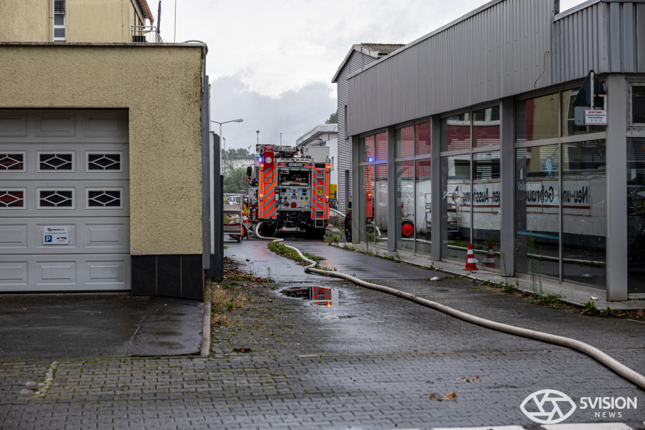 Schwarzer Rauch, gesperrte Straßen und dutzende Einsatzkräfte – technischer Defekt löst Feuer in Neufahrzeug-Lager aus.