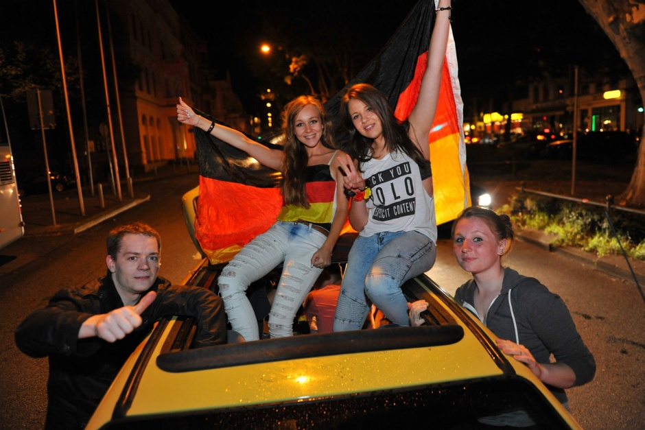 Der verdiente Vorrunden-Sieg der deutschen Nationalmannschaft gegen die Elfenbeinküste hat in der Nacht zum Sonntag den Wiesbadener Innenstadtring komplett lahmgelegt. Unmittelbar nach dem Abpfiff des packenden WM-Krimis strömten hunderte Fußballfans in die City, um den Erfolg lautstark zu feiern. Innerhalb kürzester Zeit bildete sich auf der Schwalbacher Straße und der angrenzenden Rheinstraße ein gigantischer Autokorso aus rund 300 Fahrzeugen. Während die Stimmung unter den rund 100 Schaulustigen am Straßenrand weitgehend ausgelassen war, mussten die Einsatzkräfte der Polizei massiv einschreiten: Neben dem illegalen Zünden von Pyrotechnik rief auch ein bewaffneter Partygast die Beamten auf den Plan. Eine Festnahme und ein stundenweises Verkehrschaos waren die Folge.