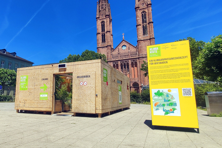 Die Klima-Kiste ist wieder in der Wiesbadener Innenstadt – und steht dieses Jahr auf dem Luisenplatz. Der begehbare Erlebnisraum bietet Abkühlung, Erholung und Informationen zu Klimathemen.Die Klima-Kiste ist wieder in der Wiesbadener Innenstadt – und steht dieses Jahr auf dem Luisenplatz. Der begehbare Erlebnisraum bietet Abkühlung, Erholung und Informationen zu Klimathemen.