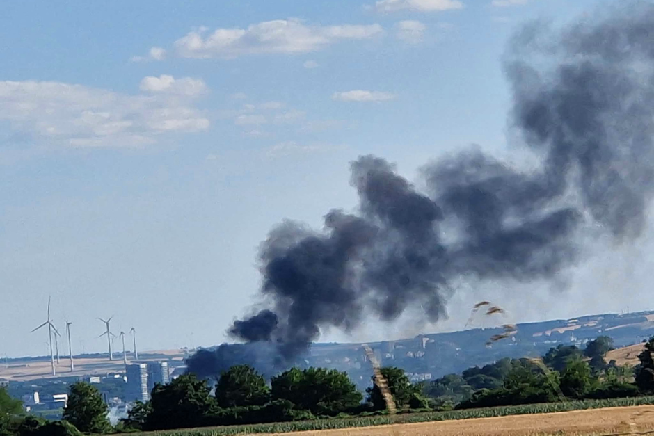Großeinsatz für die Rettungskräfte am späten Sonntagnachmittag in Wiesbaden: Im Bereich des Unteren Zwerchwegs ist ein rund 200 Quadratmeter großer Flächenbrand ausgebrochen. Zahlreiche Einsatzkräfte der Feuerwehr kämpfen gegen die Flammen. Eine massive Rauchwolke steht über dem Gebiet und ist kilometerweit zu sehen. Die Bevölkerung wird gebeten, den Bereich weiträumig zu meiden.